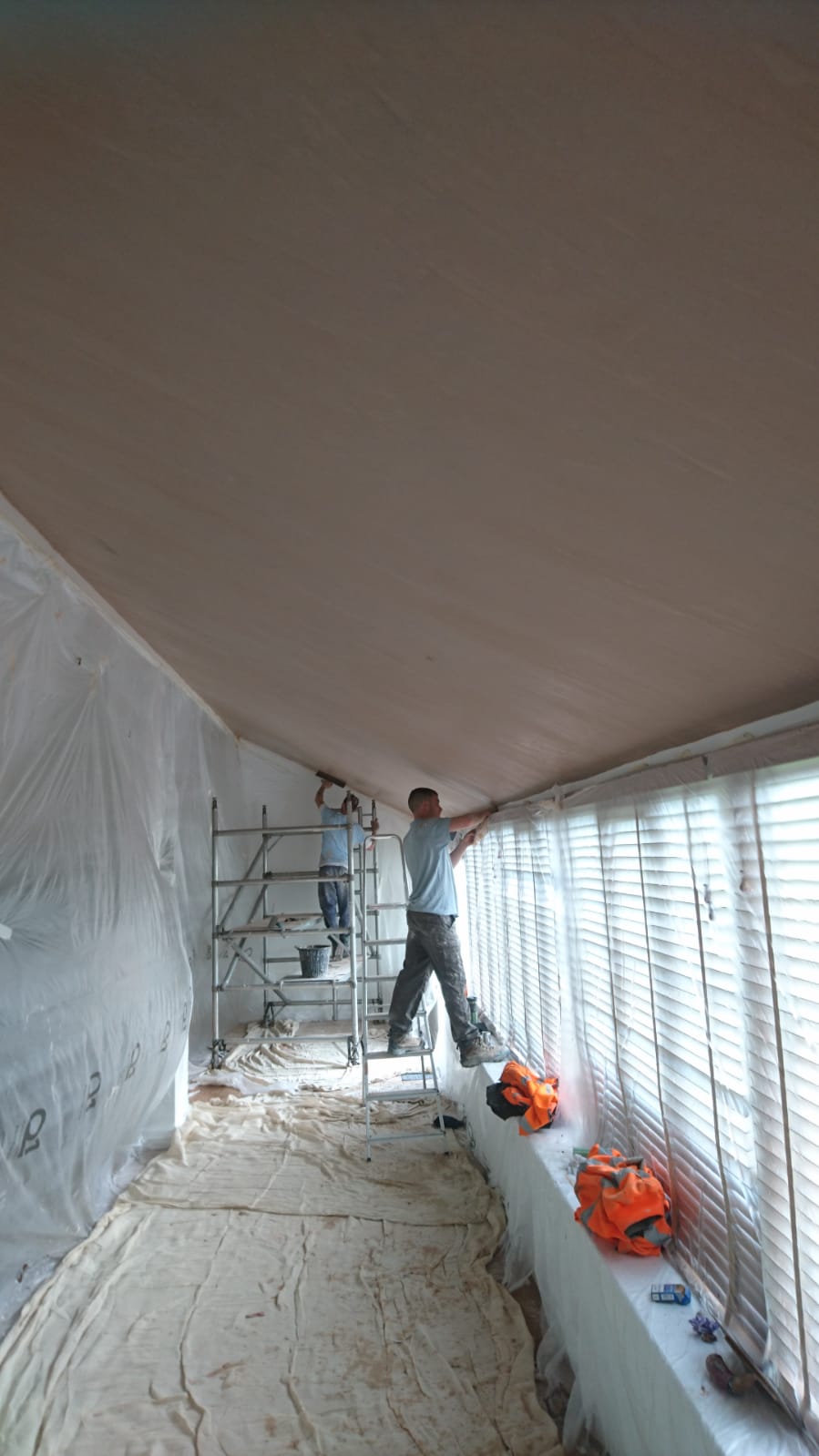 The team skimming a large ceiling with dust sheets down